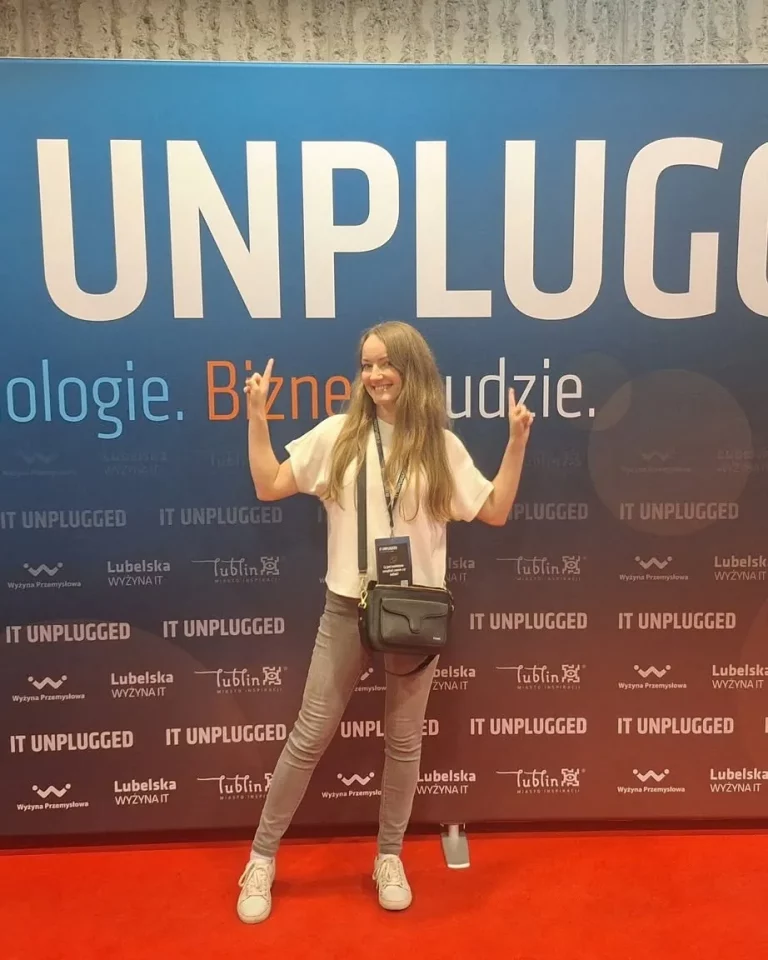 Osoba z zespołu przy ściance konferencji IT Unplugged